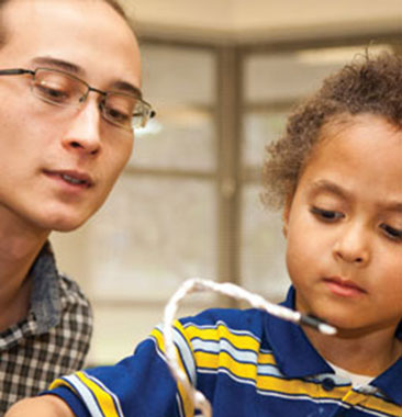 A child and a teacher working together on a science experiment