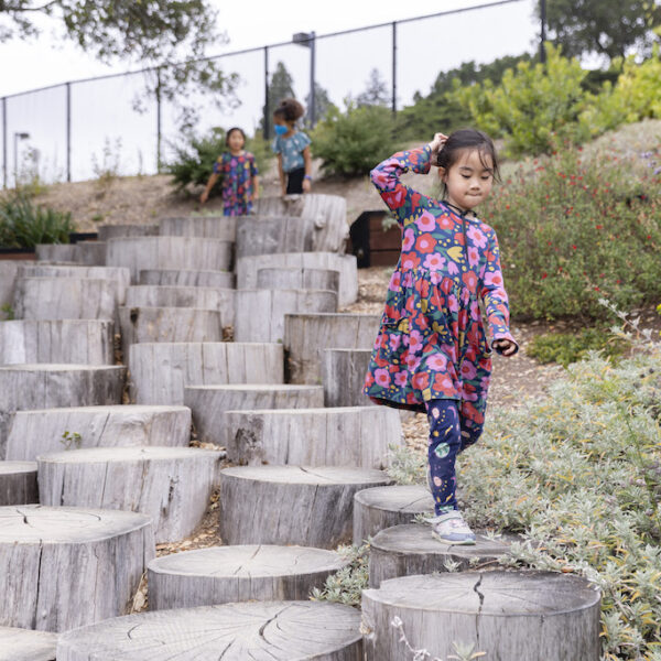 Girl walking down wood stump steps in the Outdoor Nature Lab
