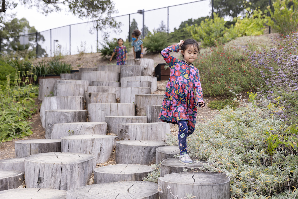 Girl walking down wood stump steps in the Outdoor Nature Lab