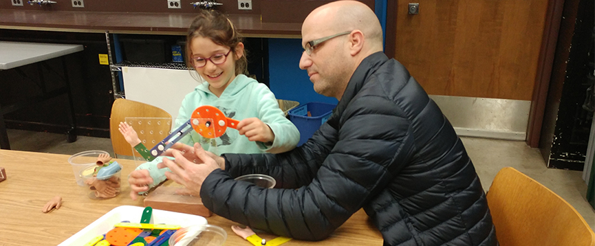 A child and an adult participating in the Ingenuity Challenges exhibit