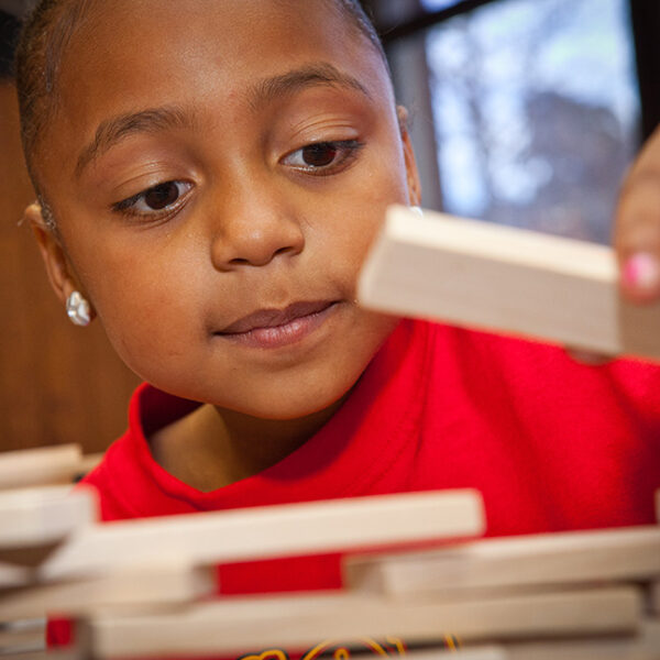 A child building with KEVA planks