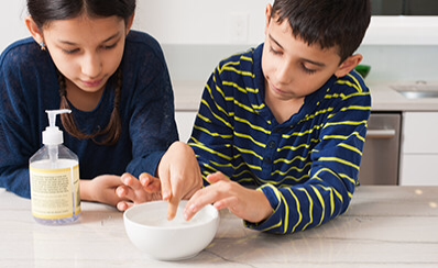 Two young people examining a bowl of water while learning about water bugs