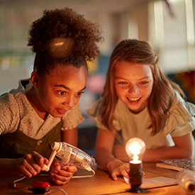 Two students are working on a FOSS science activity about electricity